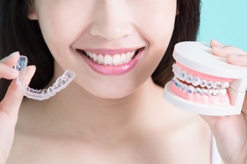 a dental patient showcasing traditional braces and clear aligners