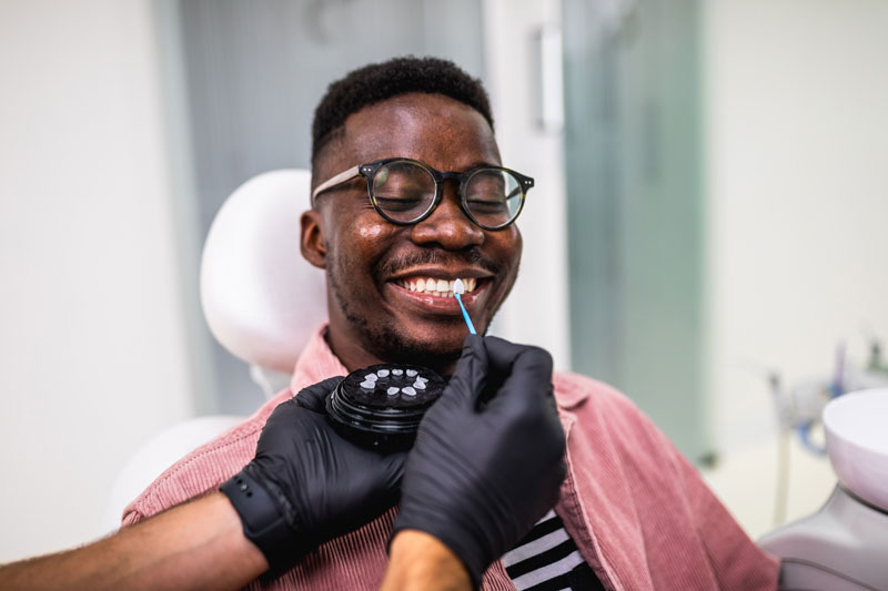 a dentist showing a patient porcelain veneer and lumineer options.