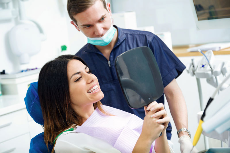 a dental implant surgery patient smiling after successfully getting dental implants