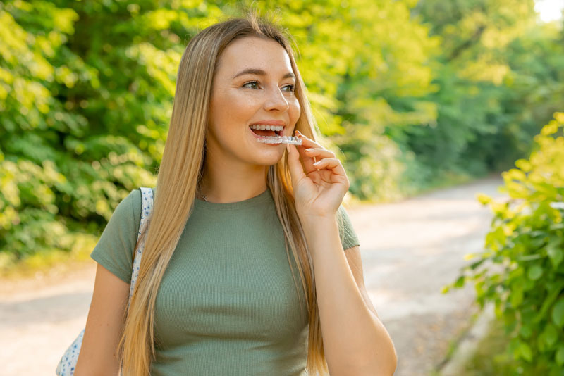 a cosmetic dental patient holding a new clear invisalign aligner.