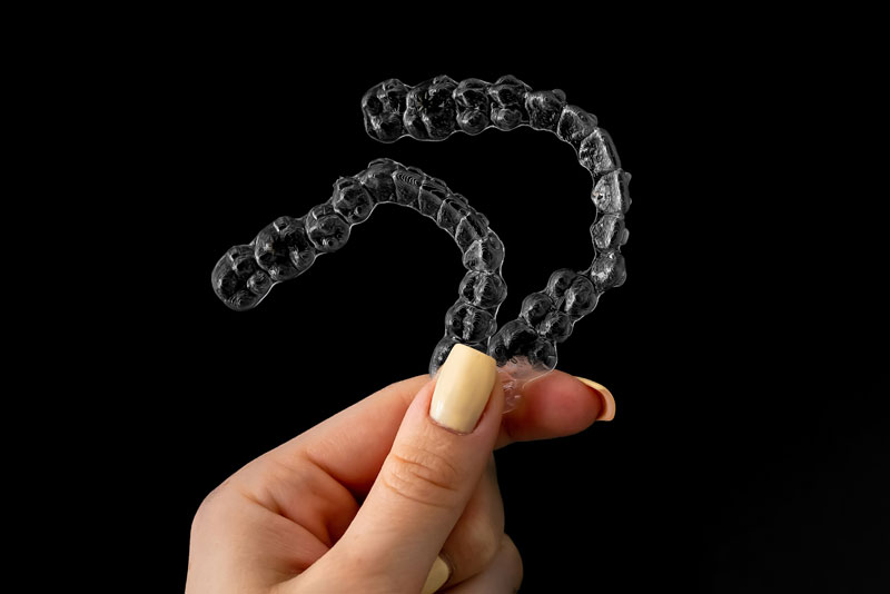 Dental Patient Holding Up Invisalign Clear Aligners